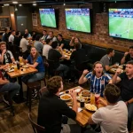 Socolive live football streaming attracting fans in a lively sports bar atmosphere.